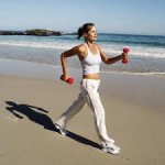 Women walking with dumbells on the beach